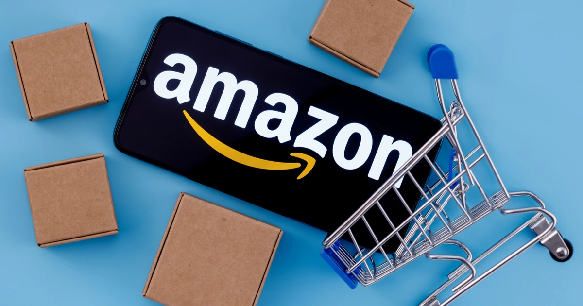 amazon app on smartphone in a miniature shopping cart