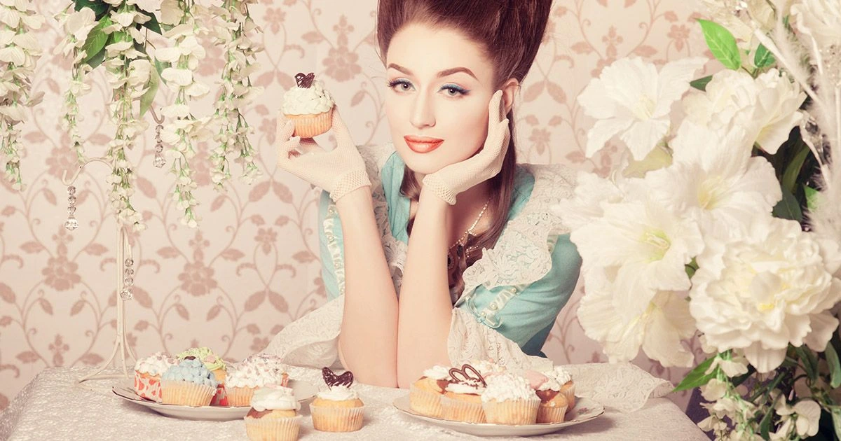 woman dressed as Marie-Antoinette holding a cupcake