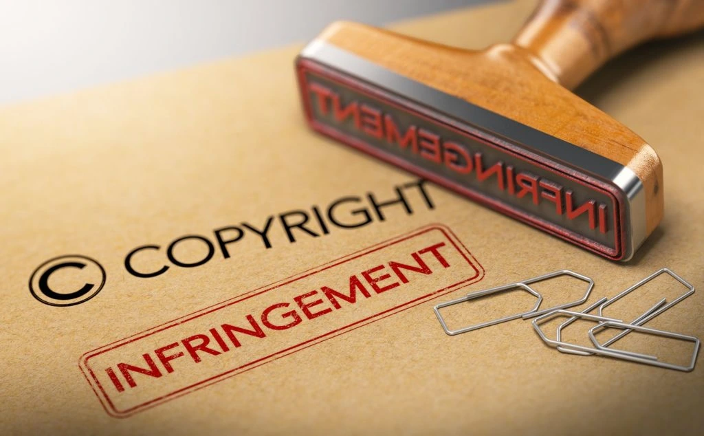 Rubber stamp and paper clips with text "Copyright" and "Infringement"