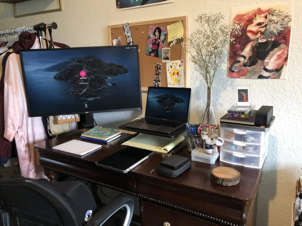 Workspace with desk, computer, and various accessories and artwork
