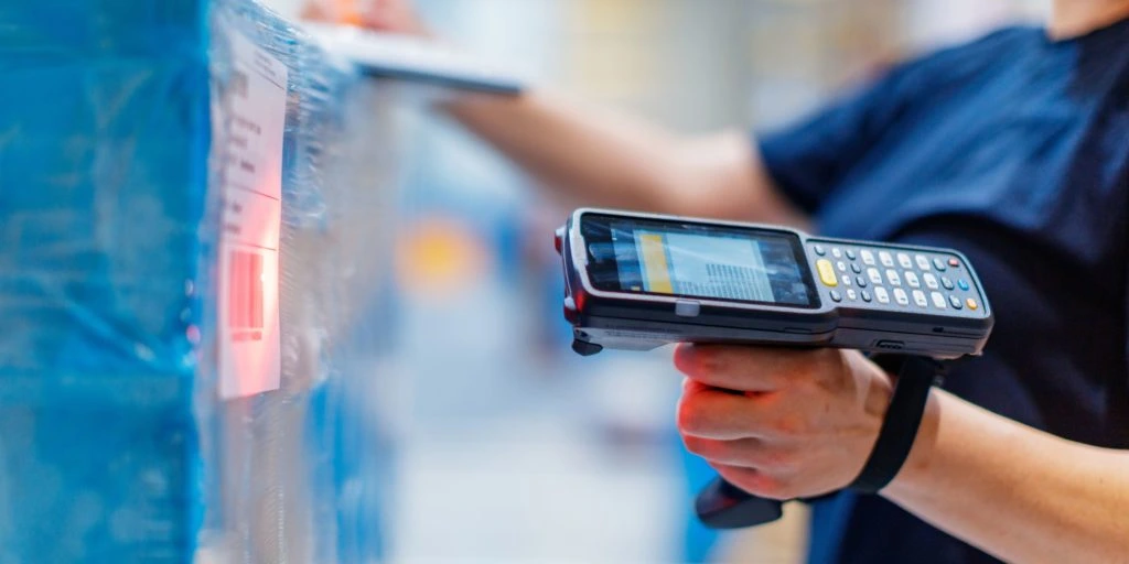 warehouse employee scanning incoming shipment with barcode scanner