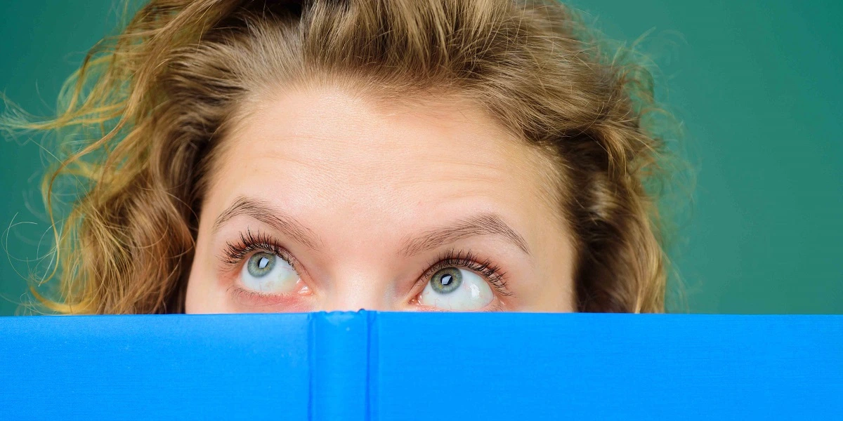 Woman looking up from book
