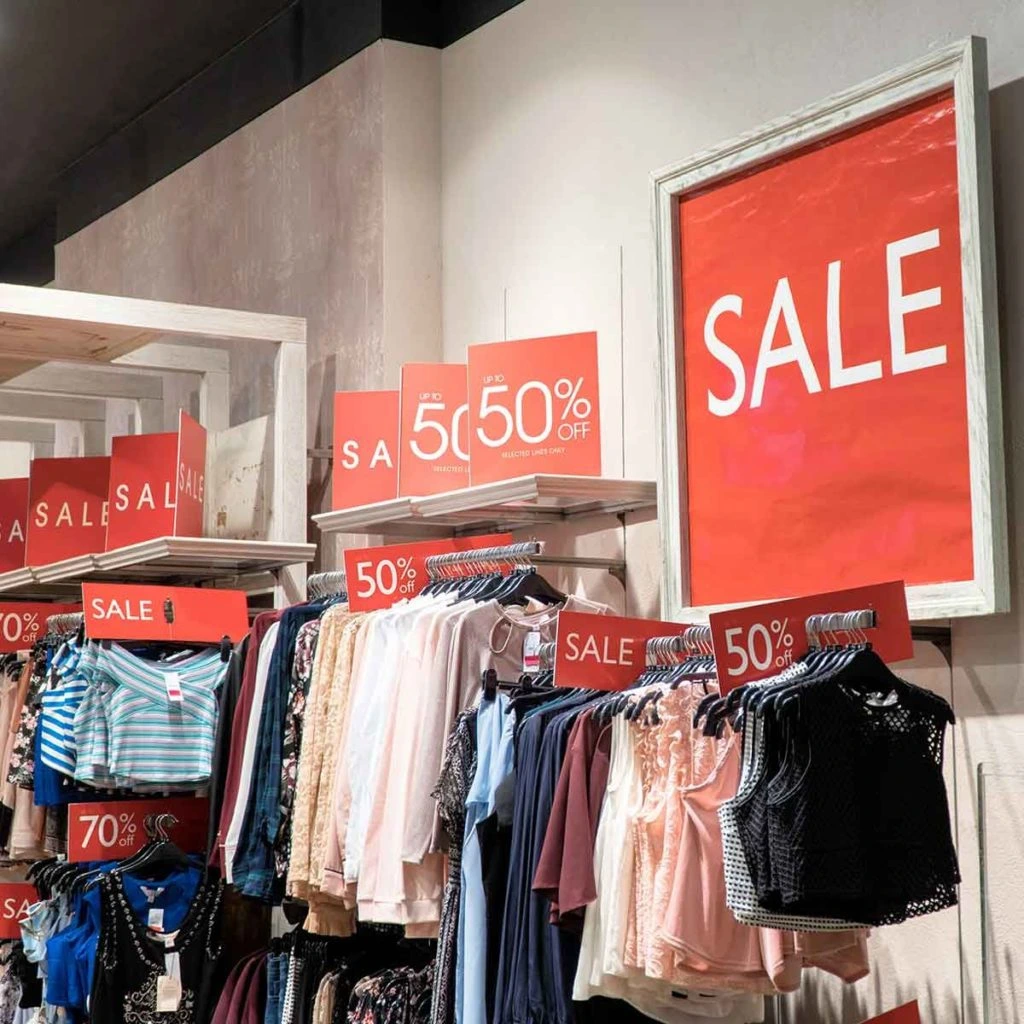 inside shot of retail store with red sale signs and racks of clothing