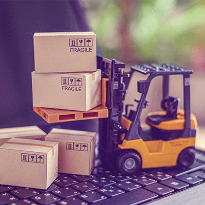 toy forklift with miniature boxes on a laptop keyboard