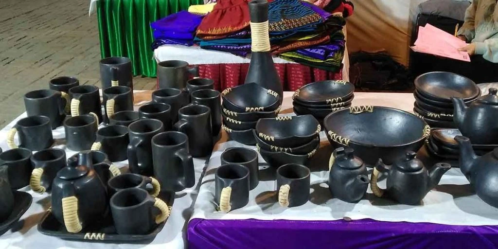assortment of black ceramic bowls, mugs, teapots, and similar tableware