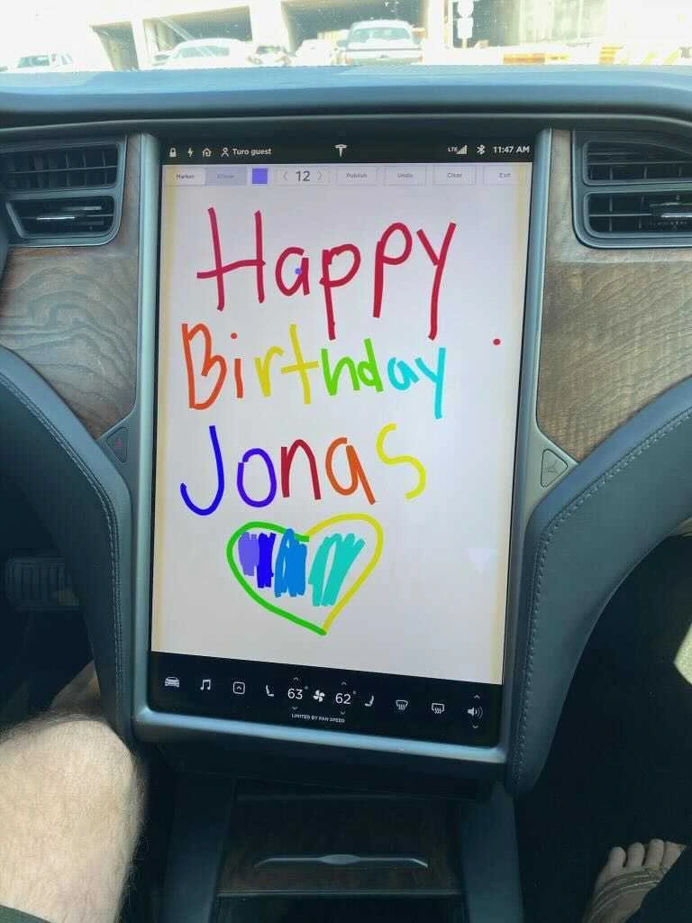 "Happy Birthday Jonas" written on center console screen of Tesla interior