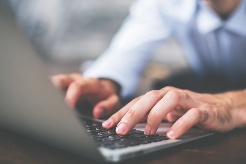 man typing on keyboard