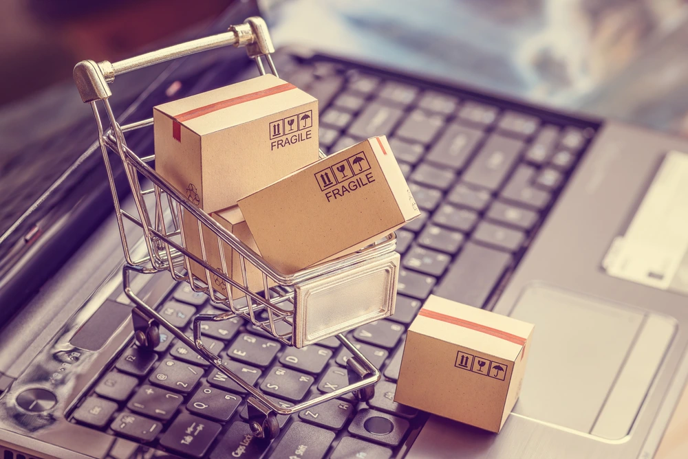 mini boxes in mini shopping cart sitting on laptop