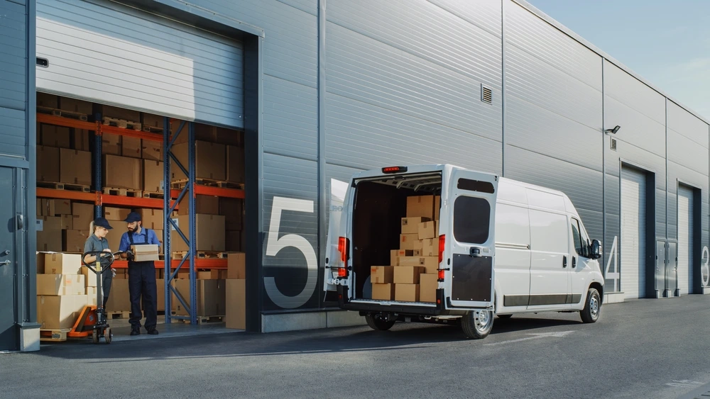 van parked outside warehouse picking up boxes