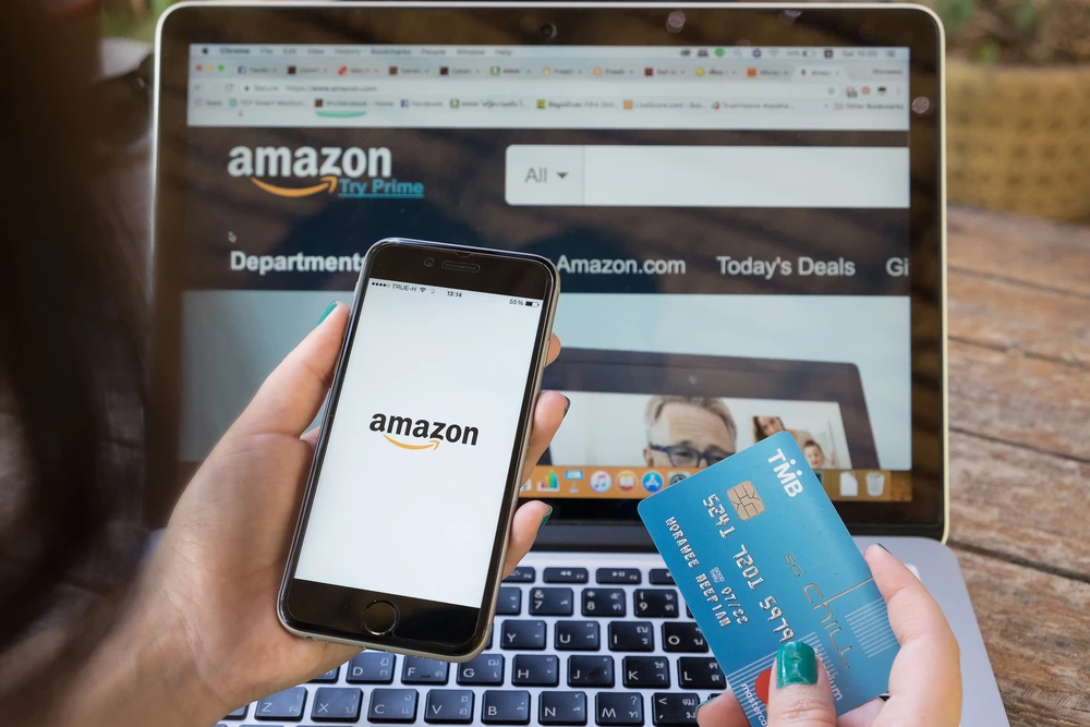 Woman making purchase on Amazon with credit card and phone
