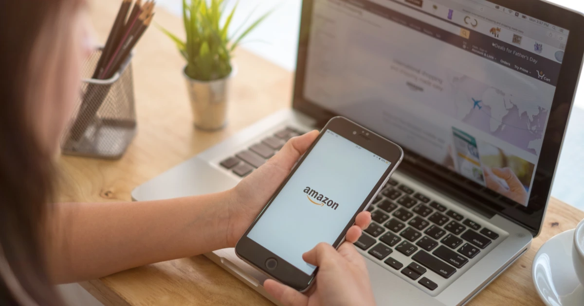 woman searching listing optimization tools on her phone and laptop