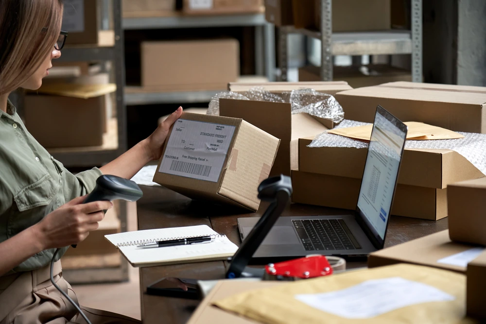 woman scanning approved amazon packages to sell at her desk